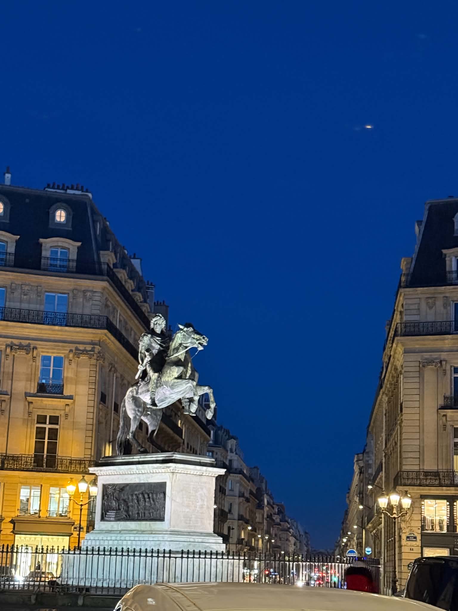 An equestrian statue on a Paris evening